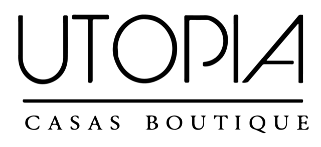 Logo with the word UTOPIA in large, modern black letters above a line, and the words CASAS BOUTIQUE in smaller black letters below the line on a light background.